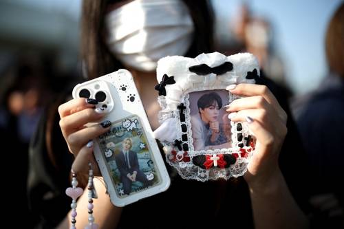 MUSIC-BTS/MILITARY A BTS fan poses for photographs as she waits for BTS members Jungkook and Jimin who are set to be discharged from South Korea?s mandatory military service, in Yeoncheon, South Korea, June 11, 2025. REUTERS/Kim Hong-Ji TPX IMAGES OF THE DAY <Copyright (c) Yonhap News Agency prohibits its content from being redistributed or reprinted without consent, and forbids the content from being learned and used by artificial intelligence systems.>