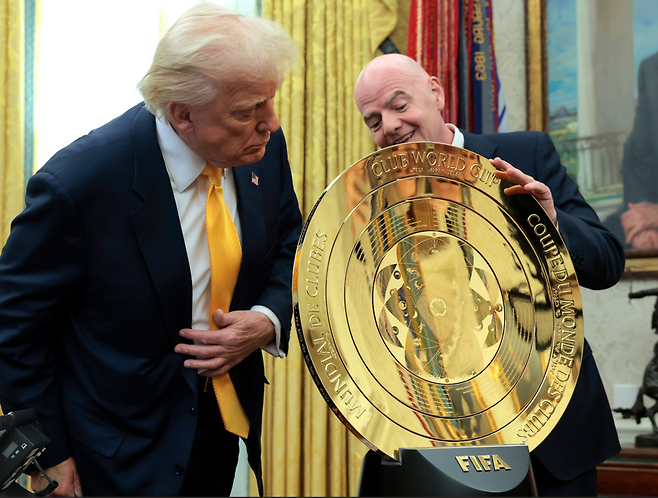 도널드 트럼프 미국대통령과 안판티오 FIFA회장이 클럽월드컵 우승 트로피를 살펴보고 있다. 게티이미지