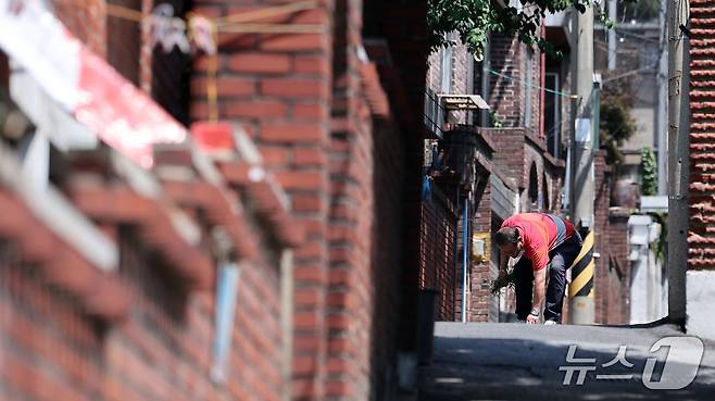 11일 서울 용산구 한남5구역에서 한 어르신이 잡초를 뜯고 있다.