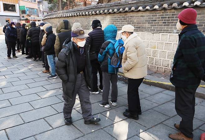 지난 2월 3일 서울 종로구 탑골공원 원각사 노인무료급식소 앞에 어르신들이 점심식사를 위해 줄지어 서 있다./연합뉴스