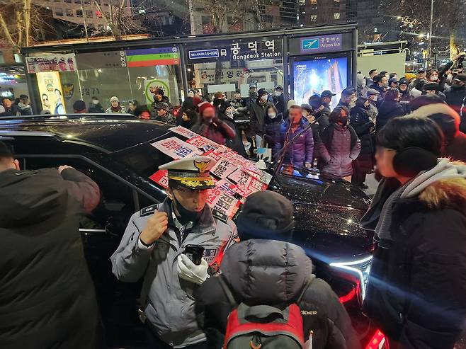 내란 우두머리 혐의로 체포된 윤석열 대통령의 구속 전 피의자심문(영장실질심사)이 종료된 지난 1월 18일 밤 서울 마포구 공덕역 인근에서 윤 대통령 지지자들이 고위공직자범죄수사처(공수처) 추정 차량의 앞을 막고 있다. 연합뉴스