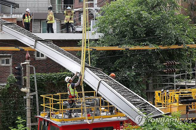 시작된 경의중앙선 복구 작업 (서울=연합뉴스) 김성민 기자 = 13일 서울 서대문구 경의중앙선 가좌역∼신촌역 구간 선로 위로 사다리차가 넘어져 관계자들이 복구 작업을 하고 있다. 이 사고로 전기공급 장애가 발생, 열차 운행이 지연되고 있다. 2025.6.13 ksm7976@yna.co.kr