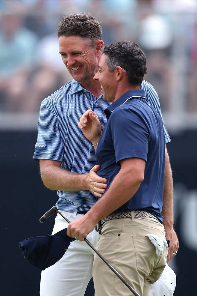 로리 매킬로이(오른쪽)가 US오픈 2라운드 18번홀에서 버디를 기록하며 본선 진출을 확정한 뒤 함께 경기한 저스틴 로즈와 웃으며 이야기 하고 있다. (사진=AFPBBNews)