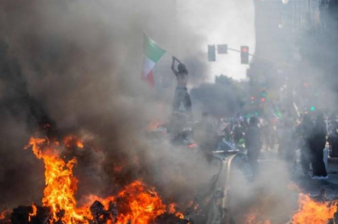 지난 8일(현지시간) 캘리포니아주 로스앤젤레스(LA)에서 시위대가 멕시코 국기를 흔드는 모습. AFP연합뉴스