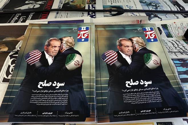 지난 3일 이란의 수도 테헤란의 한 가판대에 마수드 페제시키안(왼쪽) 이란 대통령과 도널드 트럼프 미국 대통령이 권투 글러브를 착용한 채 포옹하는 모습을 담은 표지의 잡지가 비치돼 있다. /EPA 연합뉴스