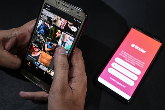 2020년 10월 6일 파키스탄 이슬라마바드에서 한 사용자가 휴대전화로 데이트 앱 그라인더(왼쪽)와 틴더를 확인하는 모습. AFP=연합뉴스