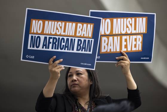 9일(현지시간) 로스앤젤레스 국제공항 톰 브래들리 국제선 터미널에서 한 시민이 도널드 트럼프 대통령의 여행 금지 조치에 항의하는 시위를 하고 있다. AP=연합뉴스