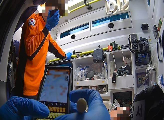 한 구급대원이 지난해 12월 서울에서 약물복용으로 의식이 혼미해진 자살시도자를 응급 이송하기 위해 수용 가능한 응급실을 확인하고 있다. 독자 제공