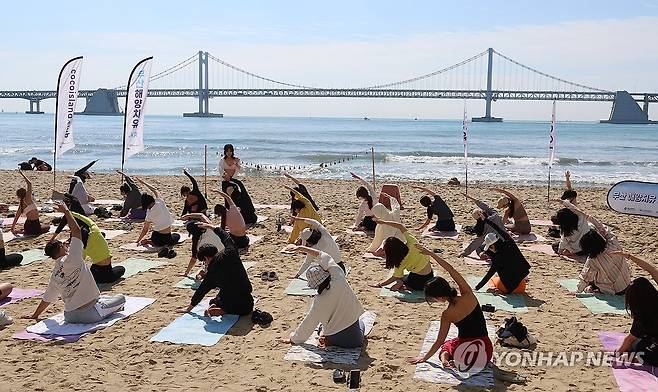 휴일 광안리해수욕장서 요가 (부산=연합뉴스) 강선배 기자 = 휴일인 25일 오전 부산 수영구 광안리해수욕장에서 휴양객과 시민들이 '2025 상반기 부산 해양치유 관광 프로그램' 해변 요가를 하고 있다.
2025.5.25 sbkang@yna.co.kr
