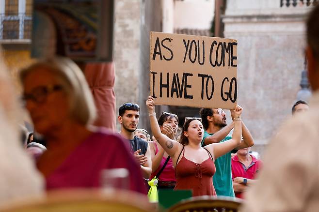 15일 스페인 마요르카에서 과잉 관광에 반대하는 시위대가 피켓을 들고 시위하는 모습./로이터 연합뉴스
