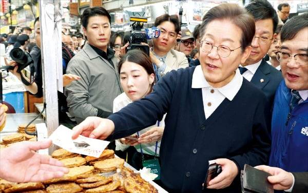 이재명 대통령이 대선 후보 시절 충북 단양 단양구경시장을 찾아 지역화폐로 떡갈비를 사고 있다. 연합뉴스
