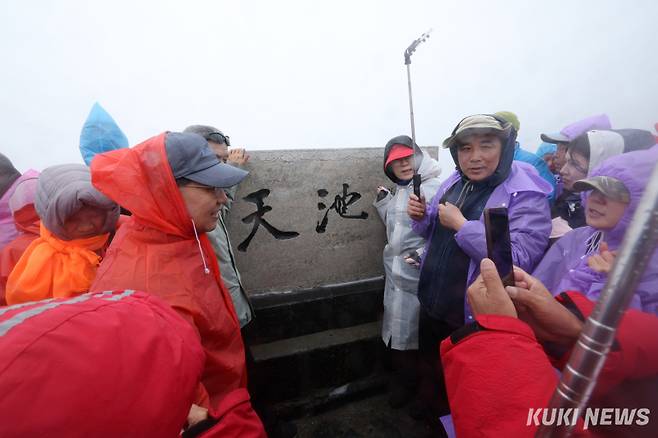 관광객들이 백두산 북파 지역 천지가 적힌 비석 앞에서 기념사진을 촬영하고 있다.