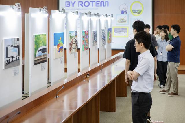 이달 12~16일까지 경기 의왕시에 위치한 현대로템 의왕연구소에서 열린 장애인 미술작가 전시회에서 현대로템 임직원들이 작품을 살펴보고 있다. 현대로템 제공.