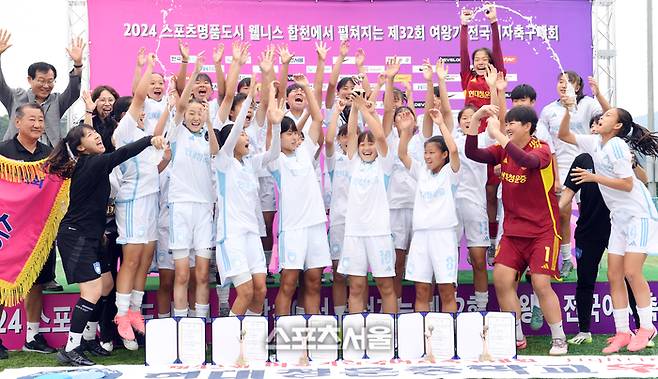 울산 현대청운중 선수단이 27일 경남 합천군 군민체육공원에서 진행된 ‘2024 스포츠 명품도시 웰니스 합천에서 펼쳐지는 제32회 여왕기 전국여자축구대회’ 중등부 충북 예성여중과 결승전에서 승리해 우승을 차지한 뒤 트로피를 들어올리며 기념촬영을 하고 있다. 2024. 6. 27. 합천 | 박진업 기자 upandup@sportsseoul.com