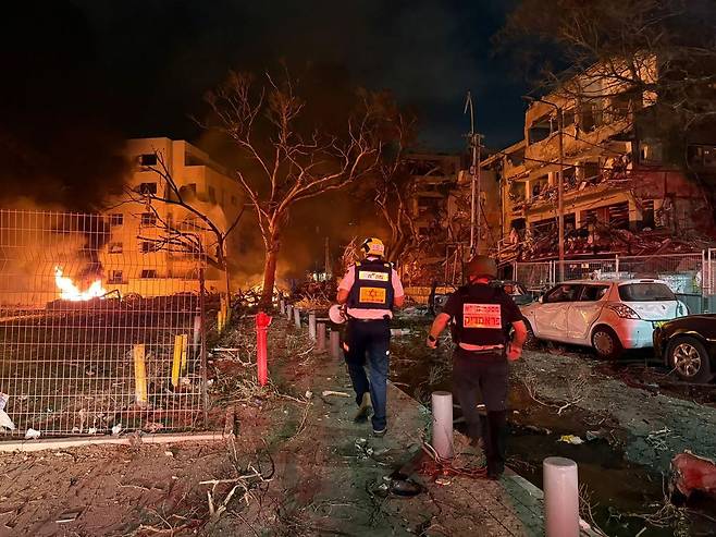 이스라엘의 긴급 구조대원들이 16일 이란에서 발사된 미사일이 텔아비브에 떨어진 현장을 조사하고 있다. UPI연합뉴스 제공