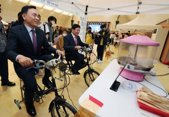 조성명(왼쪽) 서울 강남구청장이 환경 행사에 참여, 자전거를 통해 전기를 생산하는 체험을 하고 있다. 강남구 제공