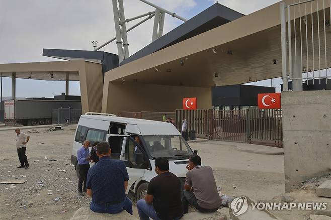 국경 통로 앞에서 기다리는 사람들 (귀르블락 AP=연합뉴스) 16일(현지시간) 귀르블락 국경을 넘어 튀르키예에 도착한 사람들이 차량 앞에 앉아서 기다리고 있다. 2025.06.17