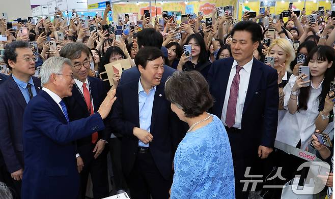 문재인 전 대통령과 김정숙 여사가 18일 오후 서울 강남구 삼성동 코엑스에서 열린 2025 서울국제도서전을 찾아 평산책방 부스에서 방문객들에게 인사하고 있다. 2025.6.18/뉴스1 ⓒ News1 박정호 기자