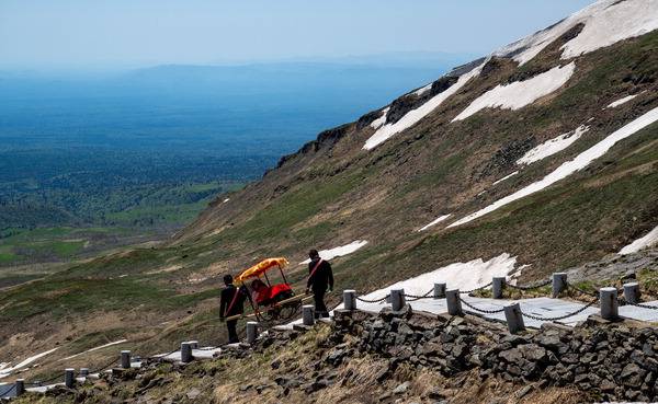 백두산 서파 1442개 계단에서 가마꾼이 관광객을 가마에 싣고 내려가고 있다. 가마 가격은 부르는게 값이다.