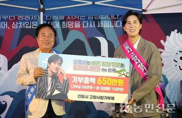 인기 트로트 가수 신유씨(오른쪽)가 13일 안동을 찾아 권기창 안동시장에게 고향사랑기부금과 답례품 쌀을 전달하고 있다. 안동시