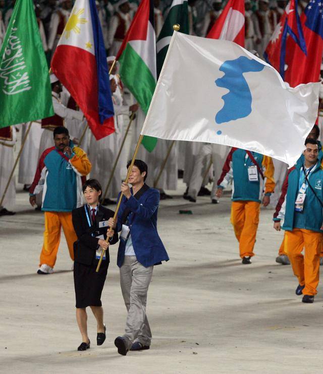 2006년 12월 2일 카타르 도하 칼리파스타디움에서 열린 도하 아시안게임 개회식에서 남측 이규섭과 북측 리금숙이 한반도기를 들고 동시에 입장하고 있다. 도하=연합뉴스