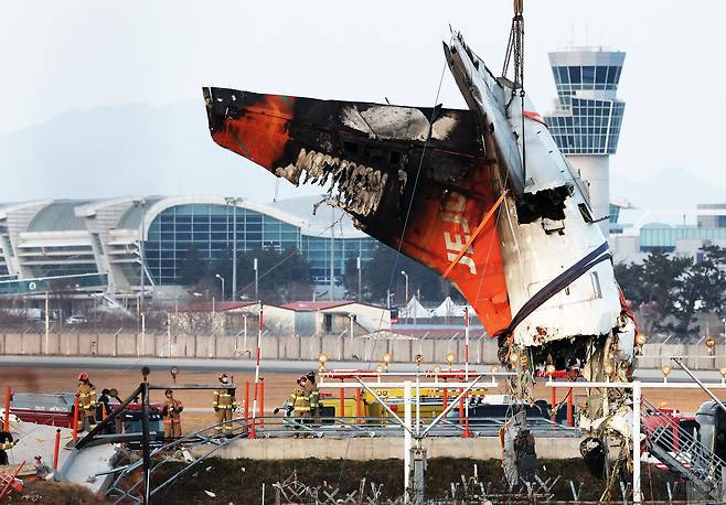 전남 무안국제공항 참사 현장에서 작년 1월 제주항공 7C2216편 사고 기체의 꼬리 부분이 크레인에 의해 인양되고 있다. /뉴스1