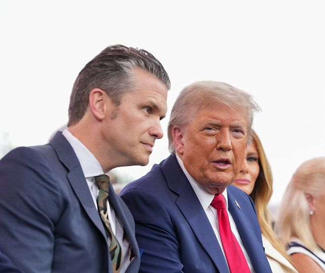 14일(현지 시간) 미국 워싱턴에서 열린 미 육군 창설 250주년 열병식에서 도널드 트럼프 대통령(오른쪽)이 피트 헤그세스 국방장관과 대화하고 있다. 트럼프 행정부는 19일 한국 등 아시아 동맹들이 국내총생산(GDP)의 5% 수준을 국방비로 지출해야 한다고 밝혔다. 워싱턴=AP 뉴시스