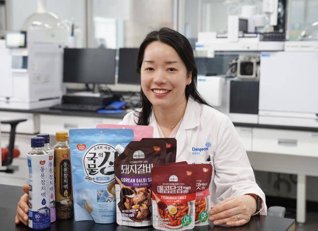 이은주 동원F&B 식품과학연구원 책임연구원이 국물의 신 등 조미료 제품들과 함께 사진을 찍고 있다. 동원F&B 제공