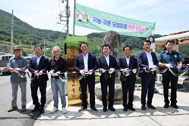 삼랑진읍 염동마을에서 열린 귀농·귀촌 모범마을 현판식 테이프 컷팅 장면