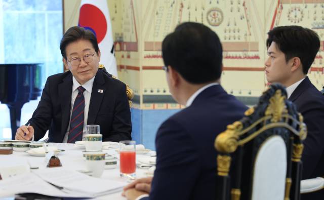 ▲이재명 대통령이 22일 한남동 관저에서 열린 여야 지도부와의 오찬에서 국민의힘 송언석 원내대표(뒷모습)의 발언을 듣고 있다. 오른쪽은 김용태 비대위원장. ⓒ연합뉴스