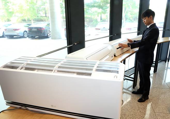 한국소비자원이 23일 정부세종청사 공정거래위원회 기자실에서 소비자 선호도가 높은 벽걸이형 에어컨 5개 제품에 대한 성능 및 안전성 등을 시험·평가한 비교정보를 제공했다. 사진은 직원이 해당 시험제품을 살펴보는 모습. /연합뉴스