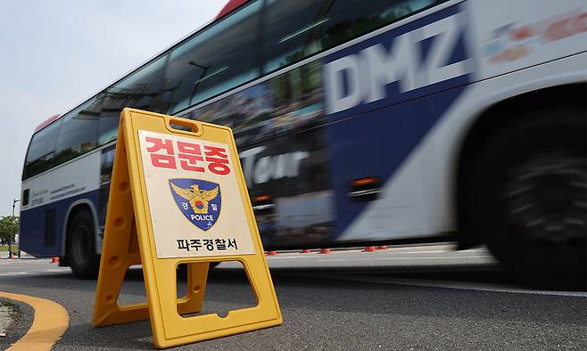 지난 19일 경기도 파주시 임진각에서 경찰의 검문 푯말 뒤로 안보관광 버스가 이동하고 있다. 연합뉴스