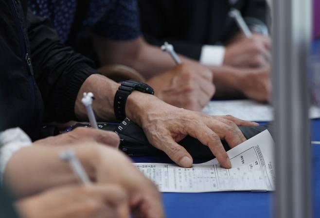 16일 오후 부산 해운대구 벡스코 제1전시장 컨벤션홀에서 열린 ‘2025 해운대구 일자리박람회’에서 구직자들이 참가 신청서를 작성하고 있다.(사진=연합뉴스)