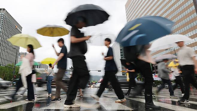 지난 20일 오전 서울 광화문네거리에서 우산을 쓴 시민들이 출근하고 있다. /뉴스1