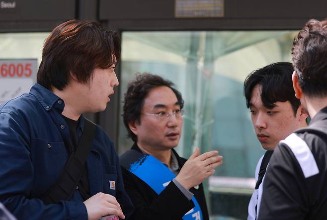 서울 중구 숭례문 인근 세종대로에서 지난 4월20일 열린 ‘의료정상화를 위한 전국의사궐기대회’에서 박단 대한전공의협의회 비상대책위원장(왼쪽)과 이선우 대한의과대학·의학전문대학원학생협회 비대위원장(오른쪽)이 대화하고 있다. 가운데는 민복기 대구광역시의사회 회장. 연합뉴스