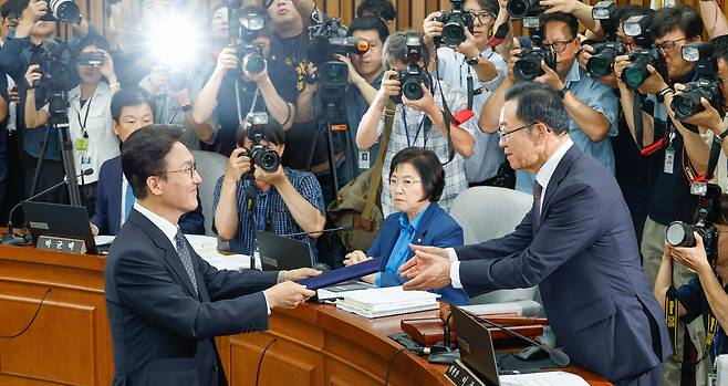 김민석 국무총리 후보자가 24일 서울 여의도 국회에서 열린 국무총리 임명동의안 심사를 위한 인사청문회에서 이종배 위원장에게 선서문을 제출하고 있다.