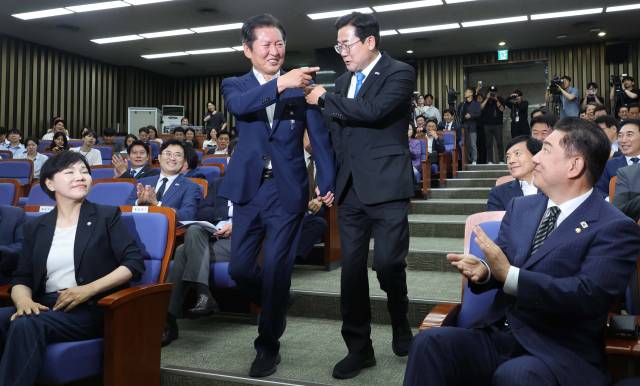 당 대표 선거 출마를 선언한 정청래(왼쪽)·박찬대 더불어민주당 의원이 24일 국회에서 열린 의원총회에 손을 잡고 참석하고 있다. 오승현 기자 2025.06.24