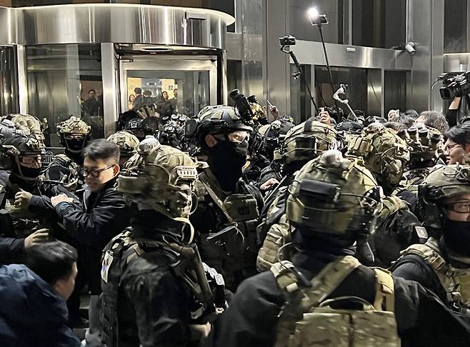 지난해 12월 4일 새벽 서울 여의도 국회의사당에 무장한 계엄군이 진입을 시도하고 있다. 연합뉴스 자료사진
