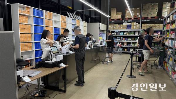 26일 메가팩토리 약국을 찾은 고객들이 계산을 하며 약사의 복약지도를 듣고 있다. 2025.6.26 /윤혜경기자 hyegyung@kyeongin.com