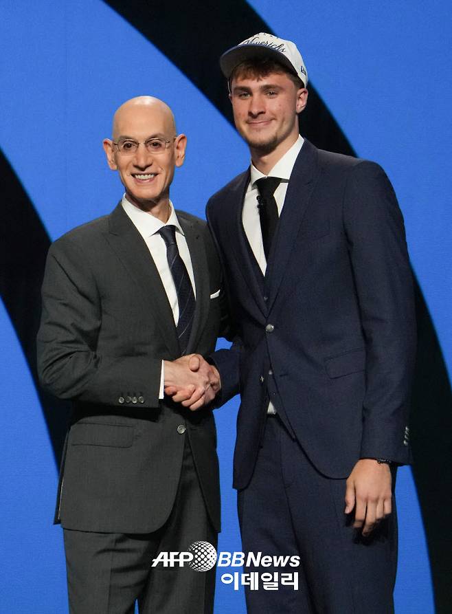 NBA 신인드래프트에서 전체 1순위로 댈러스 매버릭스에 지명된 백인 포워드 쿠퍼 플래그 애덤 실바 NBA 커미셔너와 악수를 나누고 있다. 사진=AFPBBNews