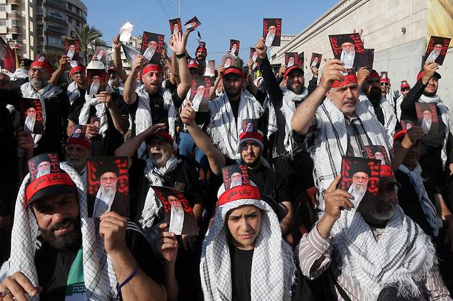 레바논에선 “이란 지지” 집회 25일(현지시간) 레바논 베이루트 주재 이란 대사관 앞에서 열린 이란 지지 집회 참석자들이 아야톨라 알리 하메네이 이란 최고지도자의 사진을 들어보이고 있다. EPA연합뉴스