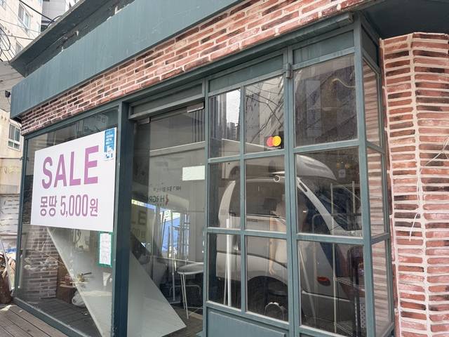 지난 23일 서울 서대문구 이화여대 앞 ‘보세 거리’(브랜드가 없는 저렴한 옷을 파는 가게들이 모인 거리)로 유명했던 골목에 빈 가게들이 늘어서 있다. 폐업 후 빈 가게 안에 자재들이 어지럽게 버려진 가운데 창밖에는 재고 물품을 5000원에 판매한다는 안내문이 붙어 있다. 이예린 기자