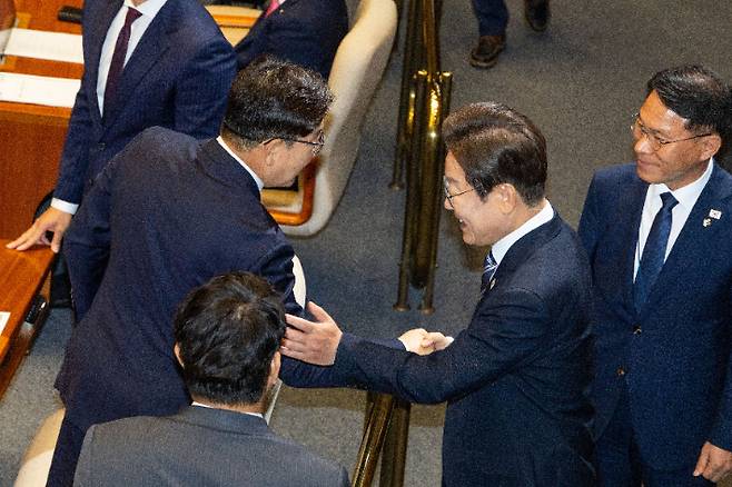 이재명 대통령이 26일 국회 본회의장에서 추가경정예산 시정연설을 마친 뒤 국민의힘 권성동 의원과 악수하고 있다. 연합뉴스