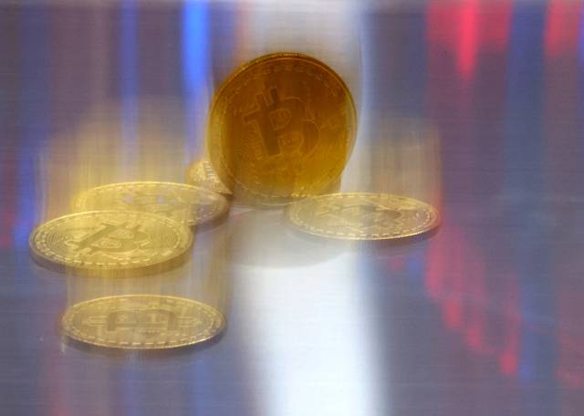비트코인 모형이 놓인 바닥에 코인 시세 그래프가 비치는 모습. 기사와는 직접적으로 무관. 연합뉴스