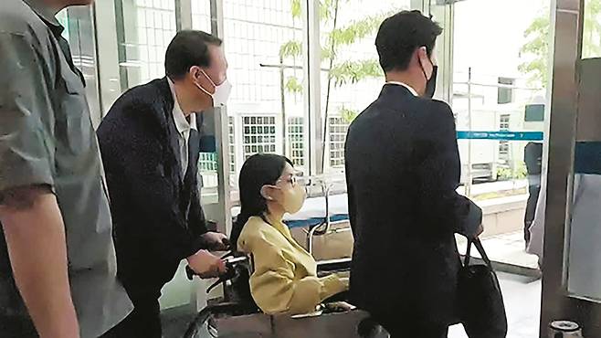 27일 오후 윤석열 전 대통령 부인 김건희 여사가 휠체어를 탄 채 입원했던 서울 송파구 서울아산병원에서 11일 만에 퇴원하고 있다. 윤 대통령이 김 여사 휠체어를 밀고 있다./KBS