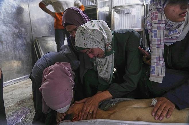 26일(현지시간) 가자지구의 시파 병원에서 이스라엘군 공습으로 숨진 남성의 시신을 놓고 유족들이 슬퍼하고 있다. AP·연합뉴스