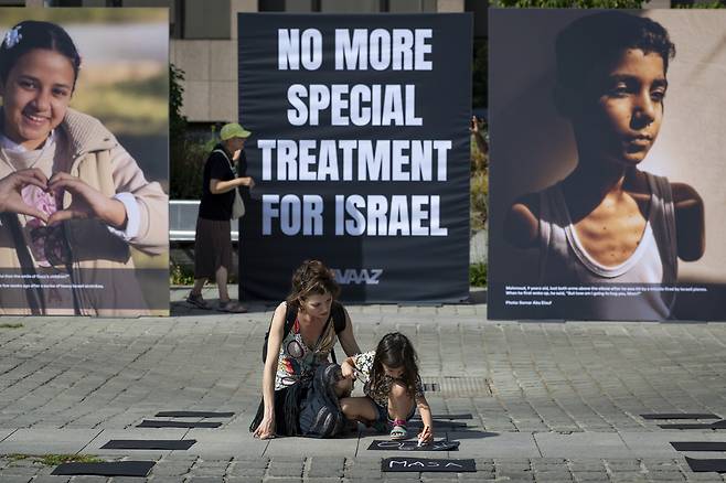 25일(현지시간) 벨기에 브뤼셀의 장 레이 광장에서 국제 캠페인 단체 아바즈가 주관한 설치 전시 ‘그들의 눈을 바라보세요(Look Them in the Eyes)’가 열렸다. 기아 위험에 처한 수천 명의 아이들을 상징하는 사진이 전시됐으며 전쟁으로 숨졌거나 위협받고 있는 어린이들을 추모하는 수백 개의 빈 배낭도 함께 놓였다. AP연합뉴스