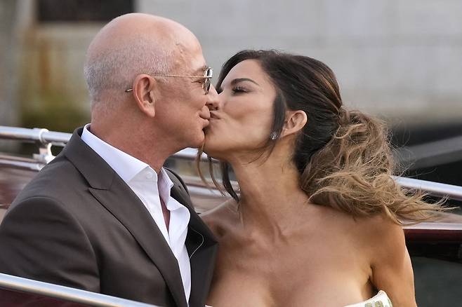 아마존 창업자 제프 베이조스와 약혼녀 로런 산체스가 26일(현지시간) 결혼 파티 참석을 위해 이동하는 요트에서 키스하고 있다. 베네치아=AP연합뉴스