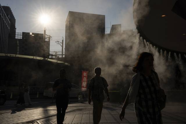 지난 17일 폭염이 닥친 일본 도쿄에서 사람들이 인공 안개를 통과하고 있다. AP연합뉴스