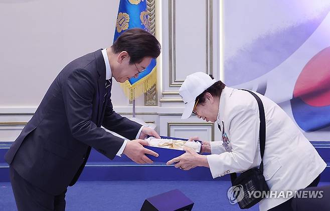 이재명 대통령, 국가유공자 초청 행사 선물 증정 (서울=연합뉴스) 한상균 기자 = 이재명 대통령이 27일 청와대 영빈관에서 열린 '호국 보훈의 달, 대통령의 초대' 행사에서 특별 초청대상자인 이춘자 씨에게 광목이불을 선물하고 있다.
이번 행사에는 국가유공자 및 유족, 보훈단체장, 특별초청자 등이 참석했다. 2025.6.27 xyz@yna.co.kr